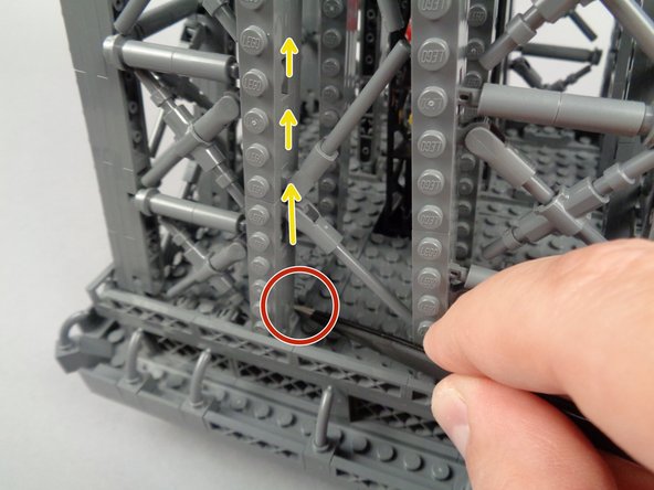 Finish removing the rear panel by pressing down with the tweezers on the left and right side base (red circle in the first and second photos) while pulling up on the rear panel (yellow arrows in both photos).