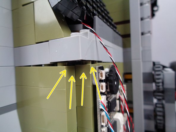 The yellow arrows in the third photo for this step show the gap in the wall you should create-- the gap should be large enough to pass the green LED light plug through.