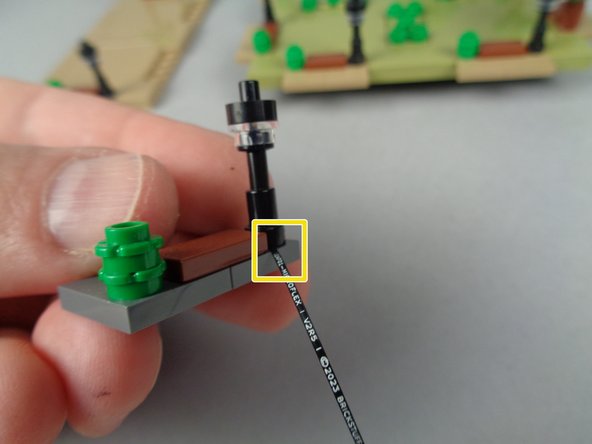 As shown by the yellow box in the second photo for this step, double-check to make sure the wire for the LED light passes out the back of the base section.