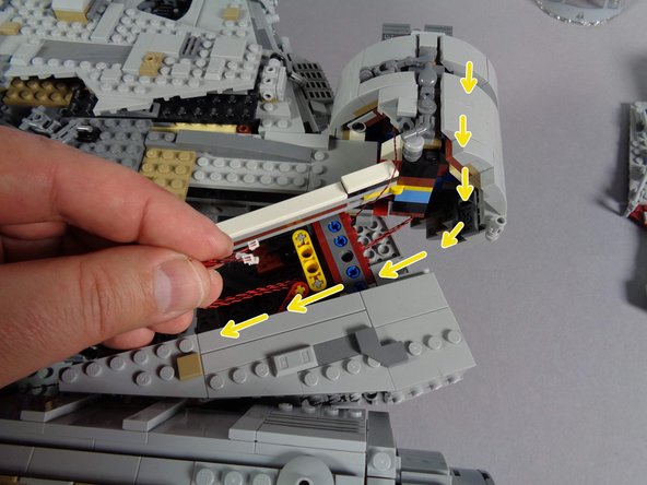 As shown by the yellow arrows in the third photo, pass the four cockpit panel light wires through the Technic brick in the Falcon frame.