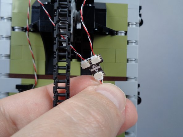 As shown in the first photo for this step, connect the two light strips to the two open plugs on the BRANCH05X adapter board.