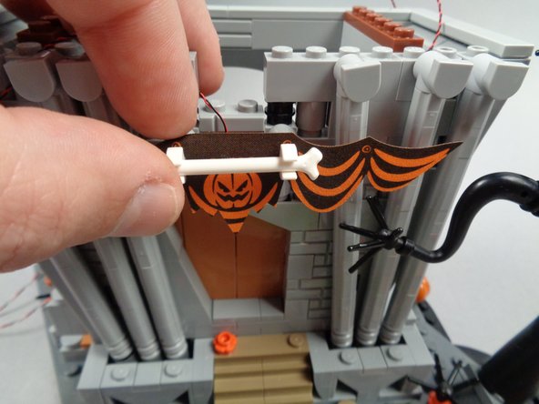 As shown in the first photo for this step, re-attach the banner.