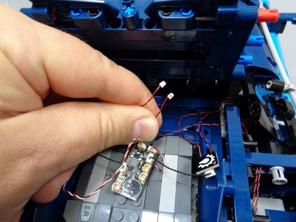 As shown in the third photo, after routing both tail light wires, you should have both cables in the center rear of the car, close to the master control board.