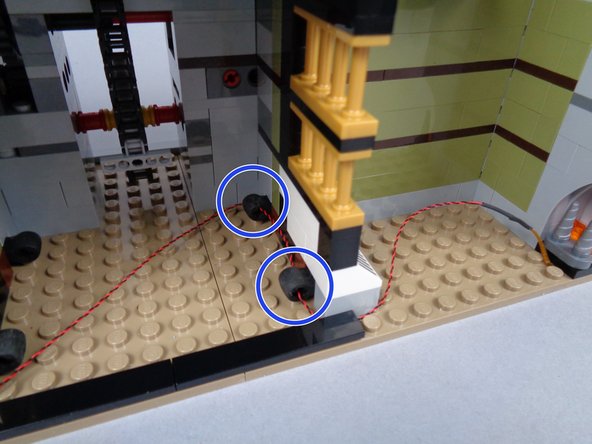 If necessary, use the tweezers to help pull the plug through the second rubber Technic part, being careful not to pull on the plug itself.