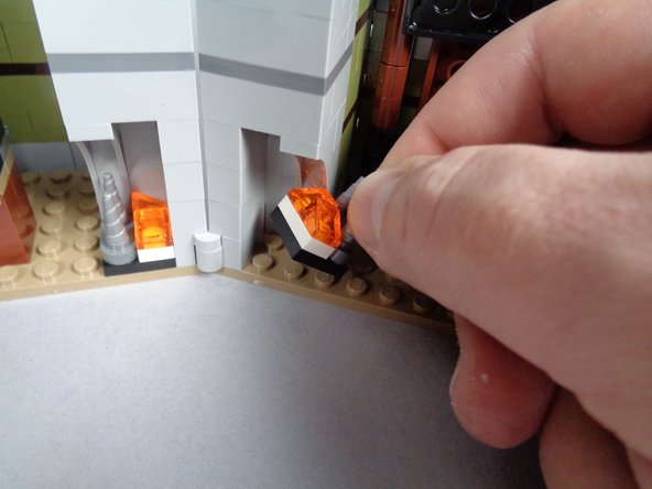 As shown in the two photos for this step, carefully remove and disassemble the fireplace on the side of the mansion closest to the front door.