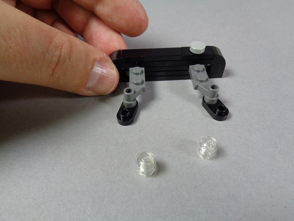 As shown in the first photo for this step, remove the transparent round plates from the black strobe brackets.