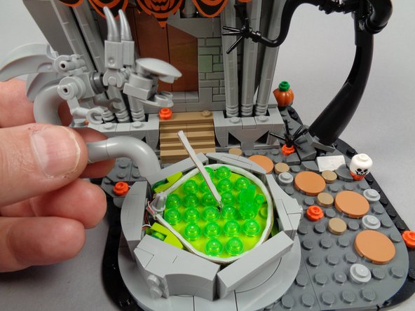 As shown in the first photo for this step, re-attach the monster statue to the fountain.