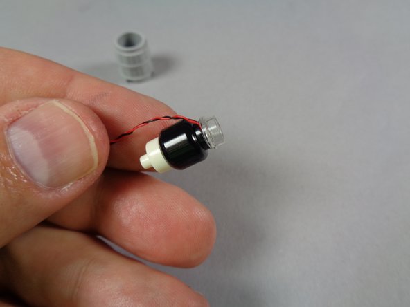 As shown in the first photo for this step, carefully re-attach the round 1x1 transparent plate on top of the black part.  Press down to secure the plate and the LED light inside.