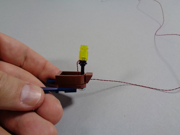 As shown in the second photo, re-attach the boat frame.  The frame will hold the LED power wire in place.