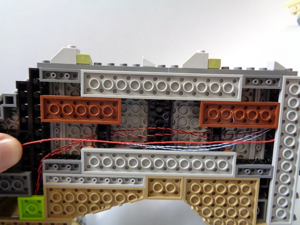 As shown in the first photo, run the red wire along the same path as the four flame wires.