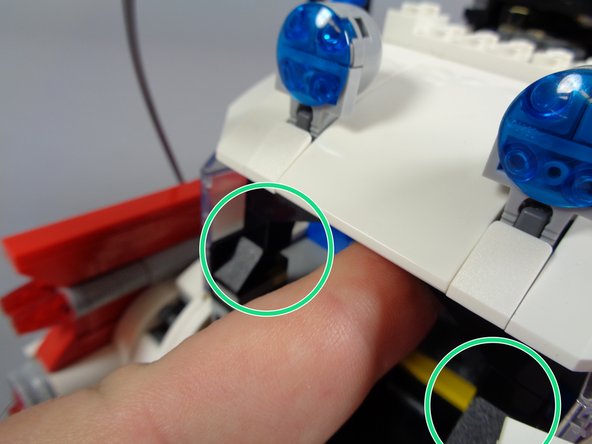As shown by the two green circles in the first photo, it can help to loosen the roof if you press up on the two black arches that anchor the roof to the car body.