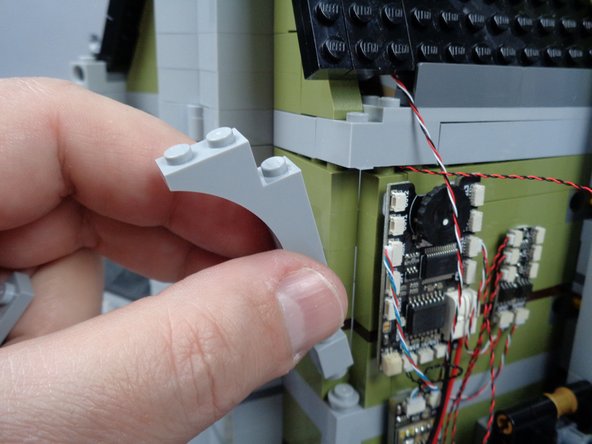 As shown in the photos for this step, re-attach the back wall parts you removed earlier to make room for the green LED light wire.