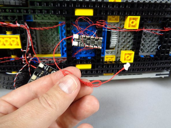 As shown in the second photo, because the red wire is much longer than needed, you can coil it up to gather the extra wire together.