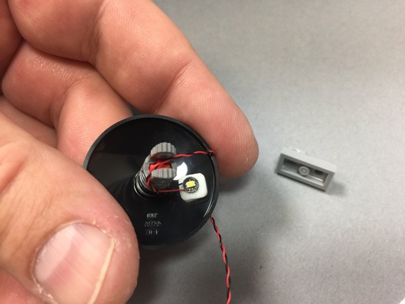 As shown in the photos for this step, remove the Dejarik holochess table from the front interior room, attach a Pico LED light to the underside using a small sticky square, and thread the LED light wire under the table and secure with the light bluish gray foot plate part.