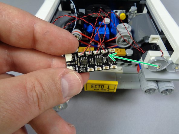 Do the same for the wire for the headlight on the left of the second assembly, then connect that light to plug #4 on the BRANCH09X adapter board as shown by the green arrow.
