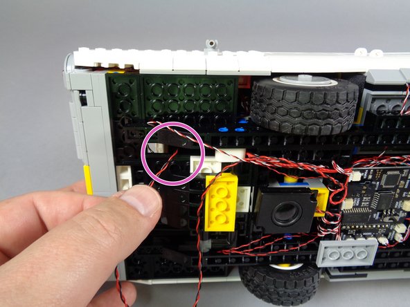 As shown by the purple circle in the second photo, feed the power wire up into the interior of your Ecto-1.