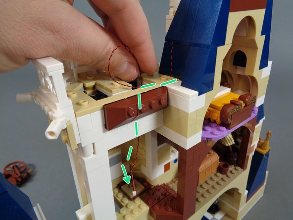 As shown by the green dotted lines in the first photo for this step, pass the light wire down into the spinning room, then down below the spinning room floor.