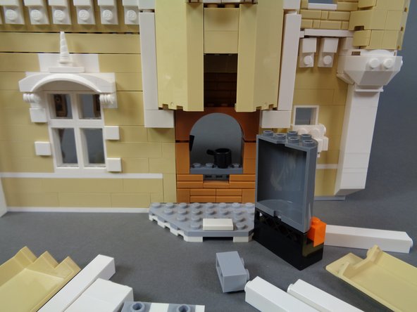 Continue disassembling the section behind the kitchen stove as shown.