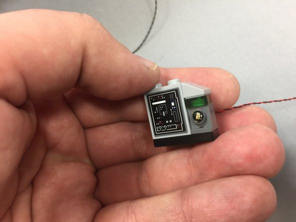 The photos here show a round transparent red plate on the control panel-- your Falcon will not have this, as the original LEGO kit does not include it.  The piece is included with your Brickstuff kit, in the same bag as the interior LED lights.