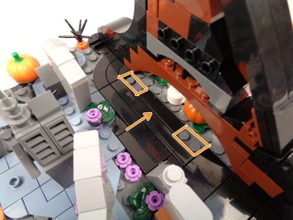 As shown by the orange arrow in the third photo for this step, re-attach one of the two tiles you removed into the center of the opening, leaving two studs open on either side.