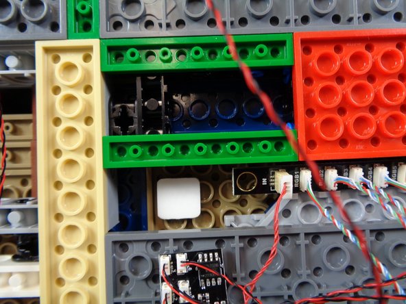 Attach one large sticky square from the &quot;Lower Level Lights and Parts&quot; bag next to the BRANCH17 adapter board, then attach the BRANCH09XS adapter board as shown in the second photo.