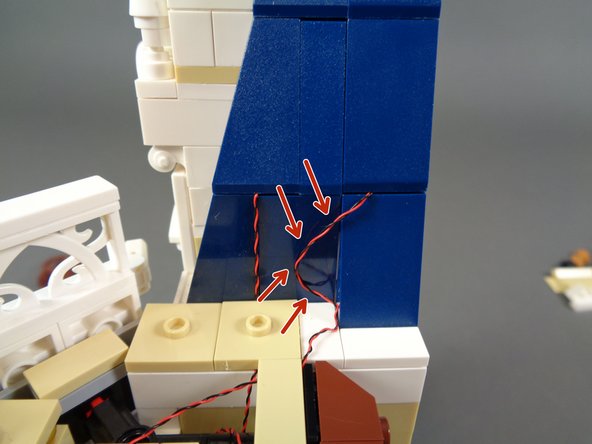 As shown in the second photo, run the light wire between the studs under the tile, then re-attach the tile.