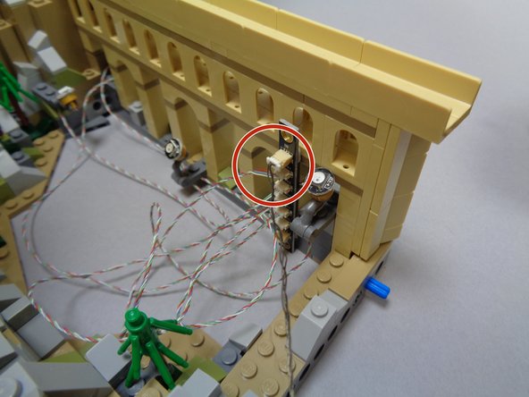 When you installed the first five color-changing spotlights and mounted the first BRANCH17 adapter board under the base of the main castle section, you had one 3-wire cable extending out from under the base.  Take that cable now and connect it to the plug on the BRANCH17 adapter labeled &quot;IN&quot; as shown in the third photo.