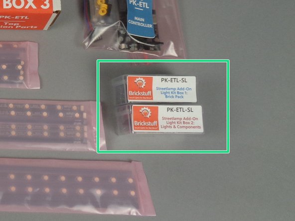 If you purchased the street lamp add-on kit at the same time as your main light kit, your kit will include the two plastic boxes shown by the green rectangle in the photo for this step.