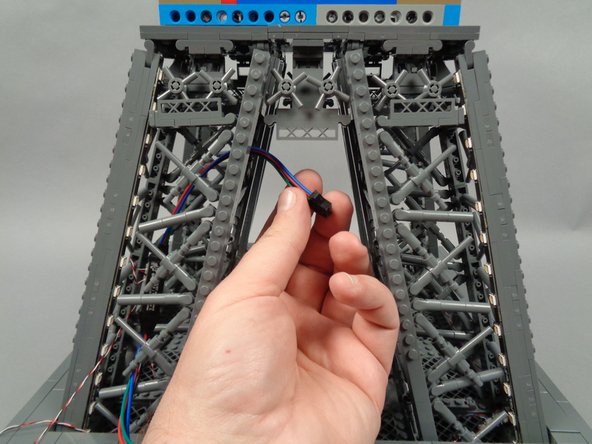 Continue feeding the female plug upward through the center of the pillar, until the board is inside the pillar and the female plug extends out near the top of the middle section as shown in the third photo.