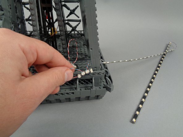 Continue passing the strips through the pillar until both the 17-LED strip and the 20-LED strip are through, as shown in the third photo.