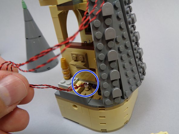 As shown by the blue circle in the photo, feed the three rooftop light wires down through the gap in the floor  next to Dumbledore's office.