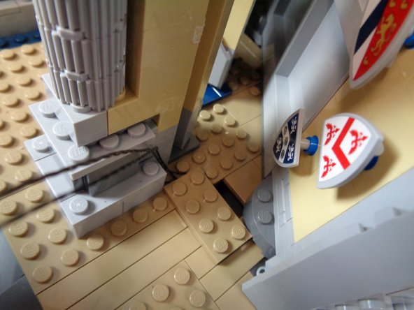 As shown in the first photo, use a brick separator to remove the tan 2x4 LEGO plate you mounted earlier, and use the 2x4 plate to hold the two wires in place as shown in the second and third photos.