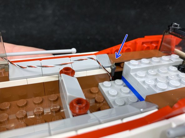 As shown in the first photo (see the blue arrow), pull the speaker wire up into the main body of the car like you did with the wire from the front hood.