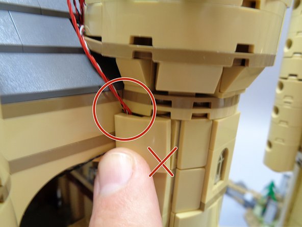 As shown in the second and third photos, make sure the wires run out the back of the tan slope (as shown by the green circles in the second photo).  DO NOT let the wires run out of the top of the tan slope as shown in the third photo-- this will damage the wires.