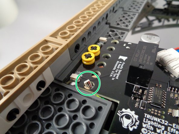 As shown by the green circle in the first photo for this step, push the other end of the control cable up through the hole in the main controller next to the plug labeled "LOOP BEGIN".
