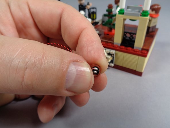 As shown in the third photo, take the orange Pico LED from the bag labeled &quot;Orange Lights&quot; and press it into the bottom of the round brown 1x1 plate.