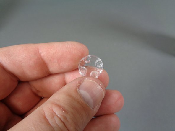 As shown in the second and third photos, take one of the clear &quot;boat stud&quot; parts from the &quot;Upper Level Lights and Parts&quot; bag, and use it to hold the ceiling light in place.