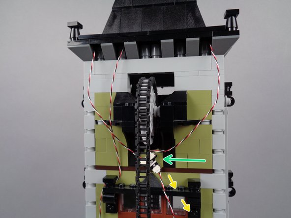 Stick the BRANCH05X adapter board with its three connected wires to the back of the tower wall, in the approximate location shown by the green arrow in the third photo for this step.