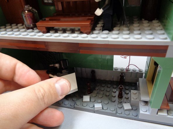 As shown in the photos for this step, remove the kitchen table and stove assembly.  Open the oven-- this is where you will mount the last orange light in the next step.