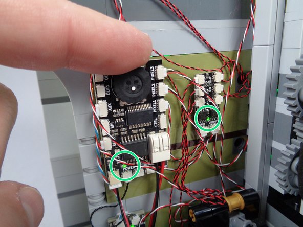 As shown by the green circles in the second photo for this step, the green LED power lights should light up on both the main effect controller and on the first BRANCH06X adapter board.
