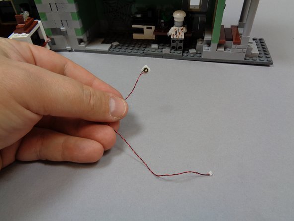 As shown in the first photo, take the last green Pico LED light with 6&quot; (15.2cm) wire and attach a small sticky square to the back.