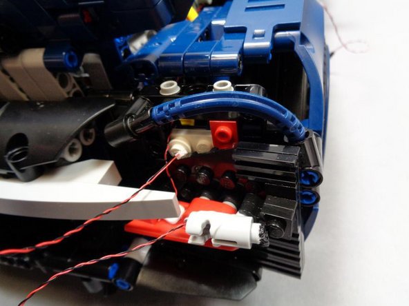 Note that on the side of the car with the wire extending downward from the &quot;blaster&quot; assembly, you will need to run the wire back up behind the &quot;blaster&quot; as shown in the second photo.