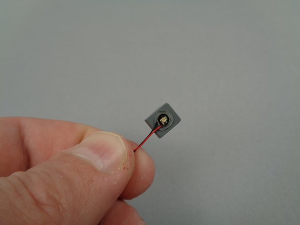 As shown in the photos for this step, take a 1x1 slope part from the extra parts from your LEGO set and attach the third yellow LED light to the slope with its wires facing downward.