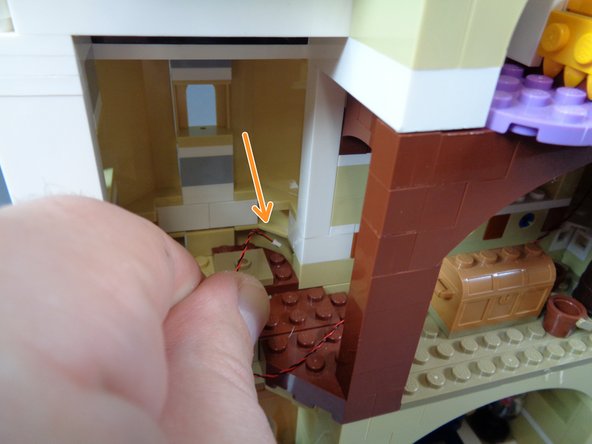 As shown by the orange arrow in the third photo, feed the light wire down underneath the floor in the spinning room.