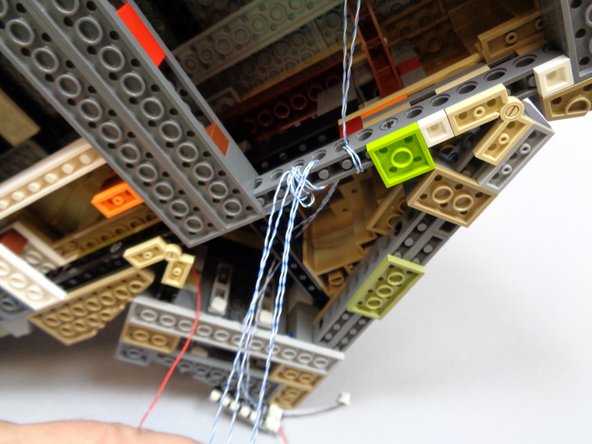 As shown in the second photo, wind the four torch light wires several times through the holes in the Technic brick so there is little slack left.