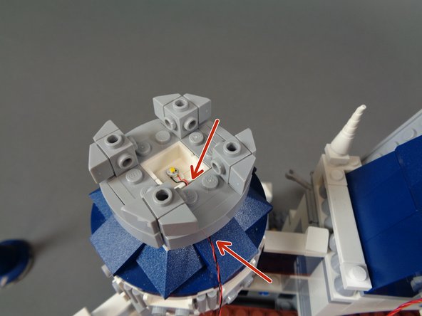 As shown in the first photo, carefully re-attach the back portion of the tower, making sure the LED light wire runs between and not on top of studs.