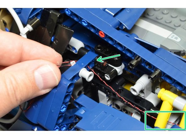 As shown in the second photo, route the left rear turn signal wire through the small hole above the black rear plate (red circle)