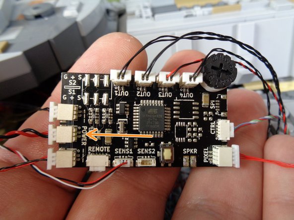 The first power wire connects to the two sound modules via the BRANCH04/A4 adapter board you connected at the beginning of the installation process.  The orange arrow in the first photo shows the power connected (thicker wire) to the BRANCH04/A4 adapter board.