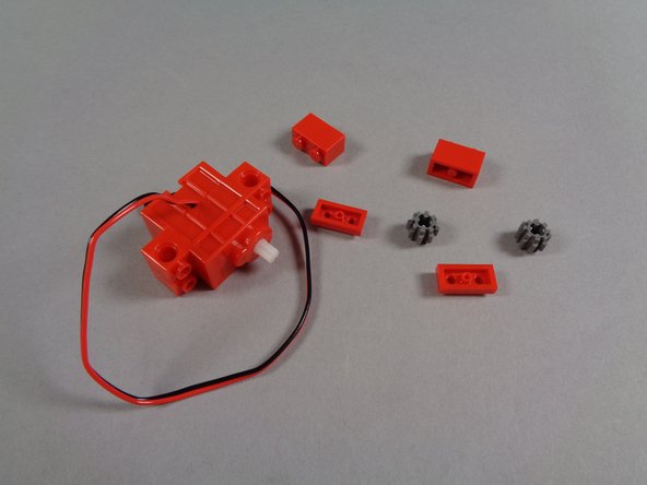 Inside your Brickstuff kit box, there will be a pink bag labeled &quot;Roof Motor.&quot;  Take the parts out of that bag.  You should have the parts shown in the second photo for this step.