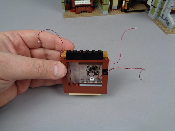 As shown in the third photo for this step, you should now have your painting frame re-assembled with wires for three LED lights extending outward.